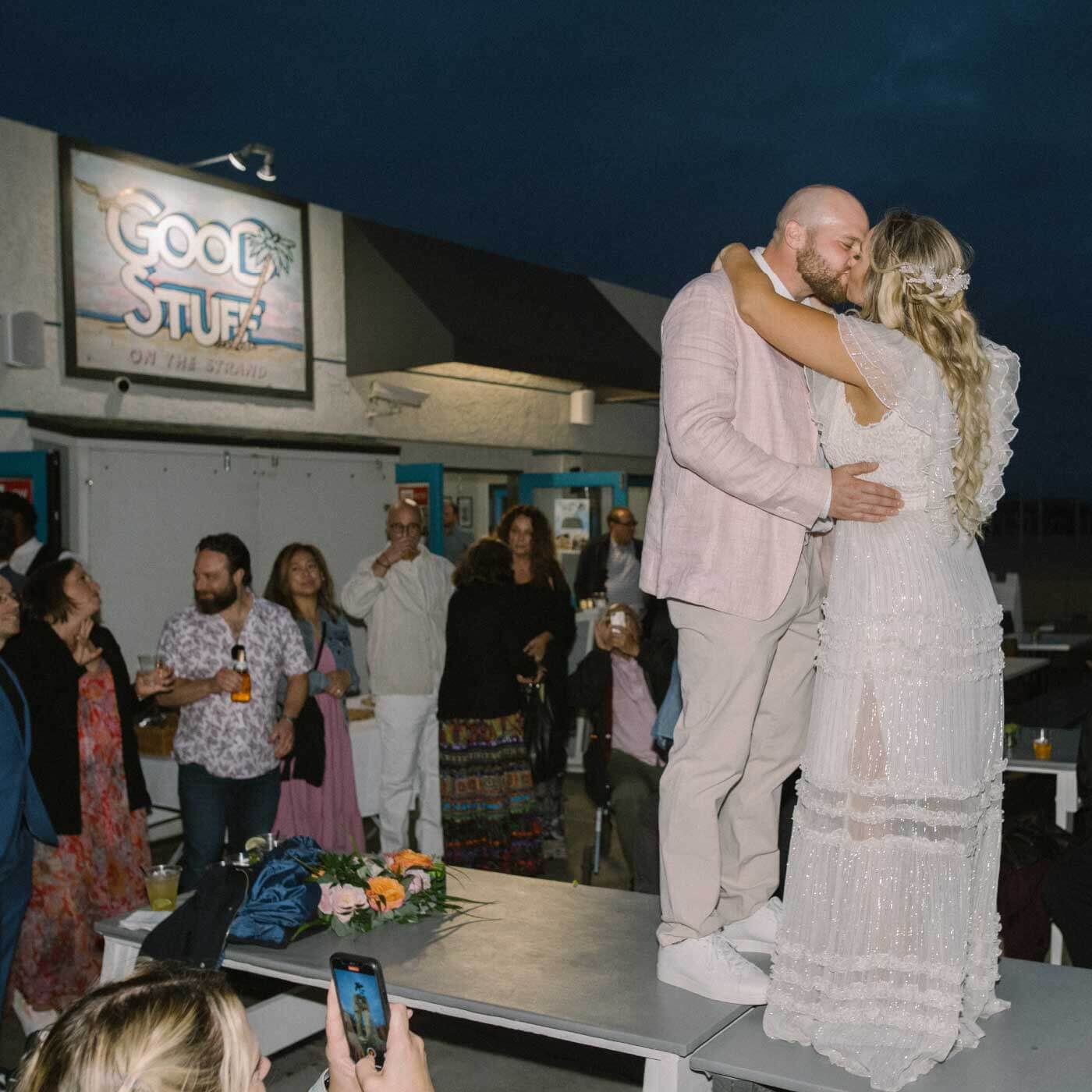 Newlyweds sharing a kiss at Good Stuff Hermosa Beach