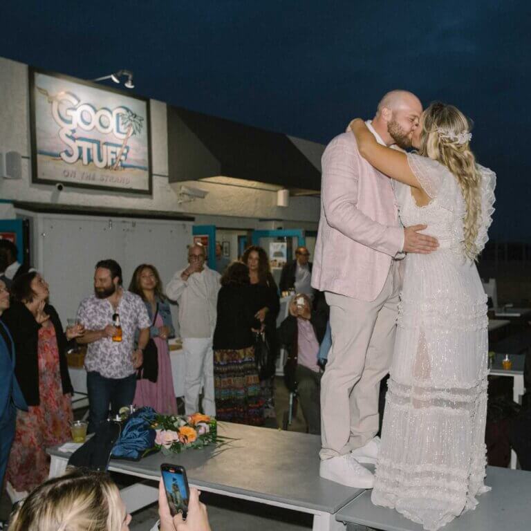 Newlyweds sharing a kiss at Good Stuff Hermosa Beach